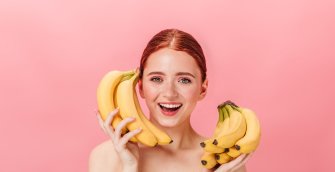 Happy woman holding tropical fruits